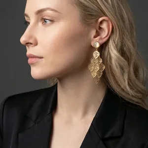 Elegant gold leaf tassel earrings with cat eye stones on a model for a vintage look