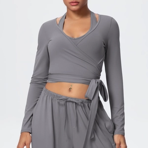 Detail of dark gray wrap-style V-neck yoga top with adjustable waist tie and long sleeves