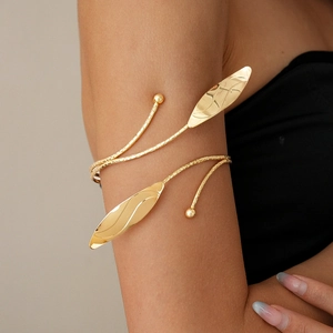 Detailed view of a gold leaf arm cuff with spiral texture and polished metal leaf details