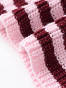 Gros plan sur le tissu en maille côtelée à rayures roses et rouge foncé, texture douce