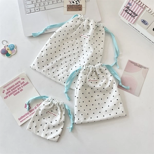 Three-piece set of white polka dot drawstring storage bags in various sizes