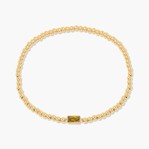 Bracelet extensible en perles dorées avec une pierre précieuse verte rectangulaire