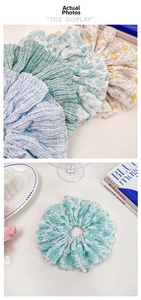 Detail of oversized floral scrunchies with pleated fabric texture in pastel colors