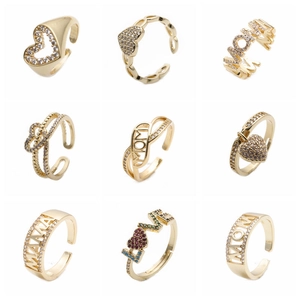 Detailansicht von neun goldenen verstellbaren Ringen mit Zirkonia-Herz und Gravuren