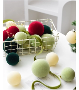 Detail of flocked Christmas ornaments in red and green with glitter in a metal basket