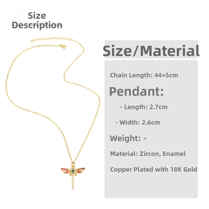 Detail of 18K gold plated dragonfly pendant with red enamel wings and green zircon