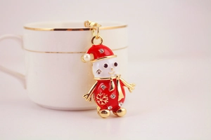 Détail d'un porte-clés bonhomme de neige en strass avec émail rouge et fermoir doré