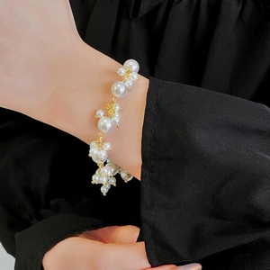 Elegant French style layered pearl bracelet with gold beads worn on a wrist
