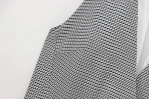 Close-up of high-density houndstooth woven fabric and neat stitching on mini dress