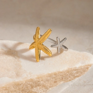 Detailed macro shot of textured gold and silver starfish on an adjustable ring band