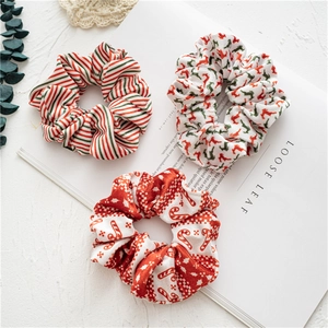 Detailed view of three festive Christmas scrunchies with reindeer and stripe patterns