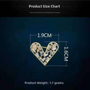 Detailed view of hollow heart brooch with clear crystals and dimensions 1.9cm by 1.6cm