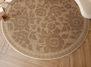 Macro detail of round jute rug with vintage floral pattern on herringbone wood floor