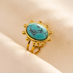 Detail of vintage turquoise ring with gold hollow geometric band and oval stone texture