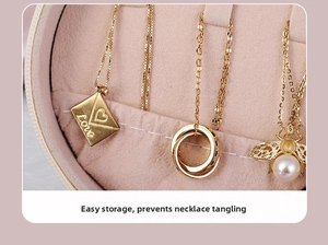 Macro view of gold necklaces with heart and bee motifs in a pink velvet jewelry box