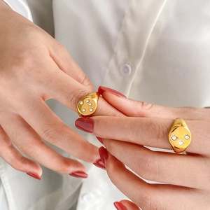 Gold plated oval signet ring set with sparkling star pattern cubic zirconia inlays