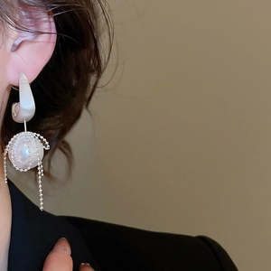 Detail view of pearl tassel earrings with silver bead net and elegant fringe chains