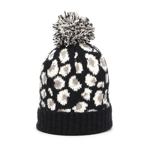 Detail of leopard print knit beanie with a three-color pompom and ribbed black cuff