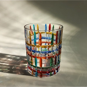 Close-up of colorful hand-painted plaid pattern on crystal glass with artistic light shadows