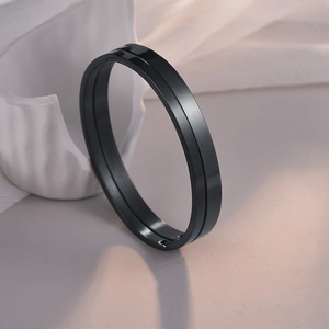 Detalle de brazalete de 4mm en acero inoxidable negro pulido con cierre en mesa blanca