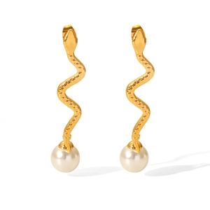 Gros plan détaillé de boucles d'oreilles serpent dorées avec perles et texture d'écailles