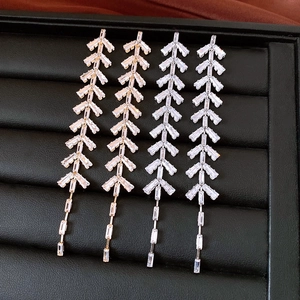 Detail of silver needle leaf tassel earrings with sparkling zircon on black leather