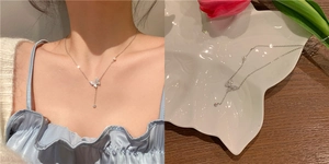 Detail of silver bow pendant necklace with sparkling crystals and pearl accents