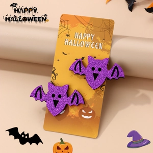 Detail of two purple glitter bat hair clips for Halloween on a themed display card