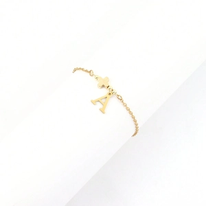 Edles Gold-Edelstahl-Armband mit Kreuz und Buchstabe A Anhänger auf weißem Hintergrund