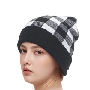 Close-up of black and white buffalo check knit beanie with ribbed cuff for winter