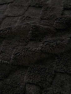 Vue macro du motif damier 3D noir sur un tissu en peluche polaire de haute qualité