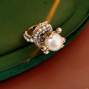 Close-up of vintage baroque flower ring with large pearl and gold metal setting