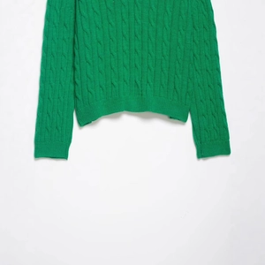 Bright green cable-knit V-neck sweater with ribbed cuffs and textured knit details