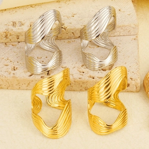 Macro view of gold and silver S-shaped wave rings on minimalist stone display