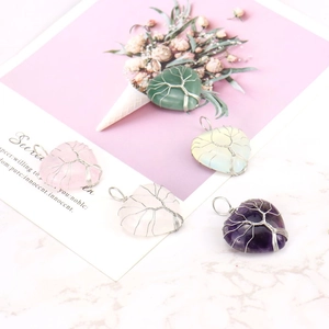 Detail shot of five diverse heart-shaped natural stone tree of life wire wrapped pendants