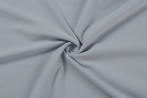 Vue macro d'un tissu en maille gris clair montrant une texture brossée douce et détaillée