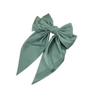 Elegant sage green satin bow hair clip with long ribbons on white background
