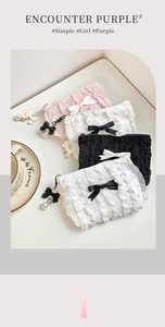 Dettaglio delle trousse a pois con pieghe, fiocchi decorativi e ciondoli di perle