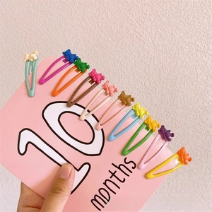 Detailed set of 10 colorful mini bear resin hair clips on a pink display card