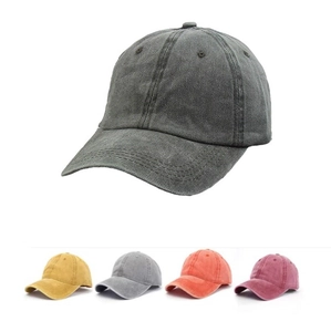 Detail view of washed cotton baseball caps showing vintage distressed fabric and color options