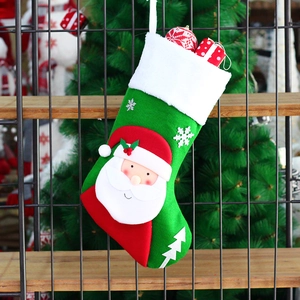 Green knitted Christmas stocking with 3D Santa Claus figure hanging on a tree