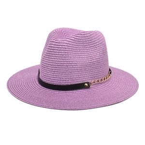 Close-up of purple straw fedora featuring a black leather band and gold chain detail