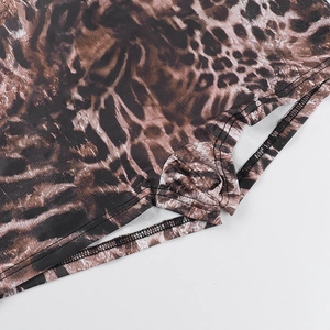 Close-up of leopard print knit fabric showing precise double-needle stitching and texture