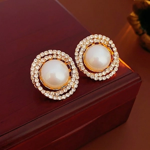 Elegant gold plated pearl stud earrings with double halo zircon stones on a jewelry box
