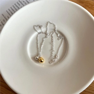 Detail of 925 sterling silver chain with dual gold and silver beads in a white tray