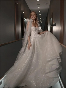 Detail of white sequin wedding dress featuring a corset bodice and mesh shoulder bows