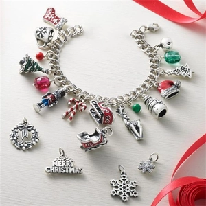 Macro shot of silver Christmas charms including Merry Christmas pendant and enamel stocking
