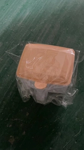 Detail view of double-compartment kitchen spice box with orange lid in protective packaging