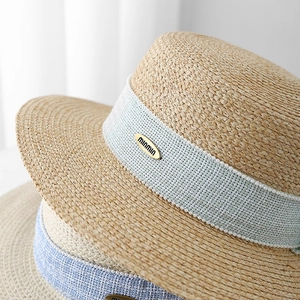 Flat top straw sun hat with blue ribbon and pearl trim for beach vacations