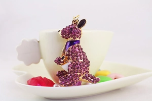 Detail view of a purple crystal encrusted kangaroo pendant on a white heart plate